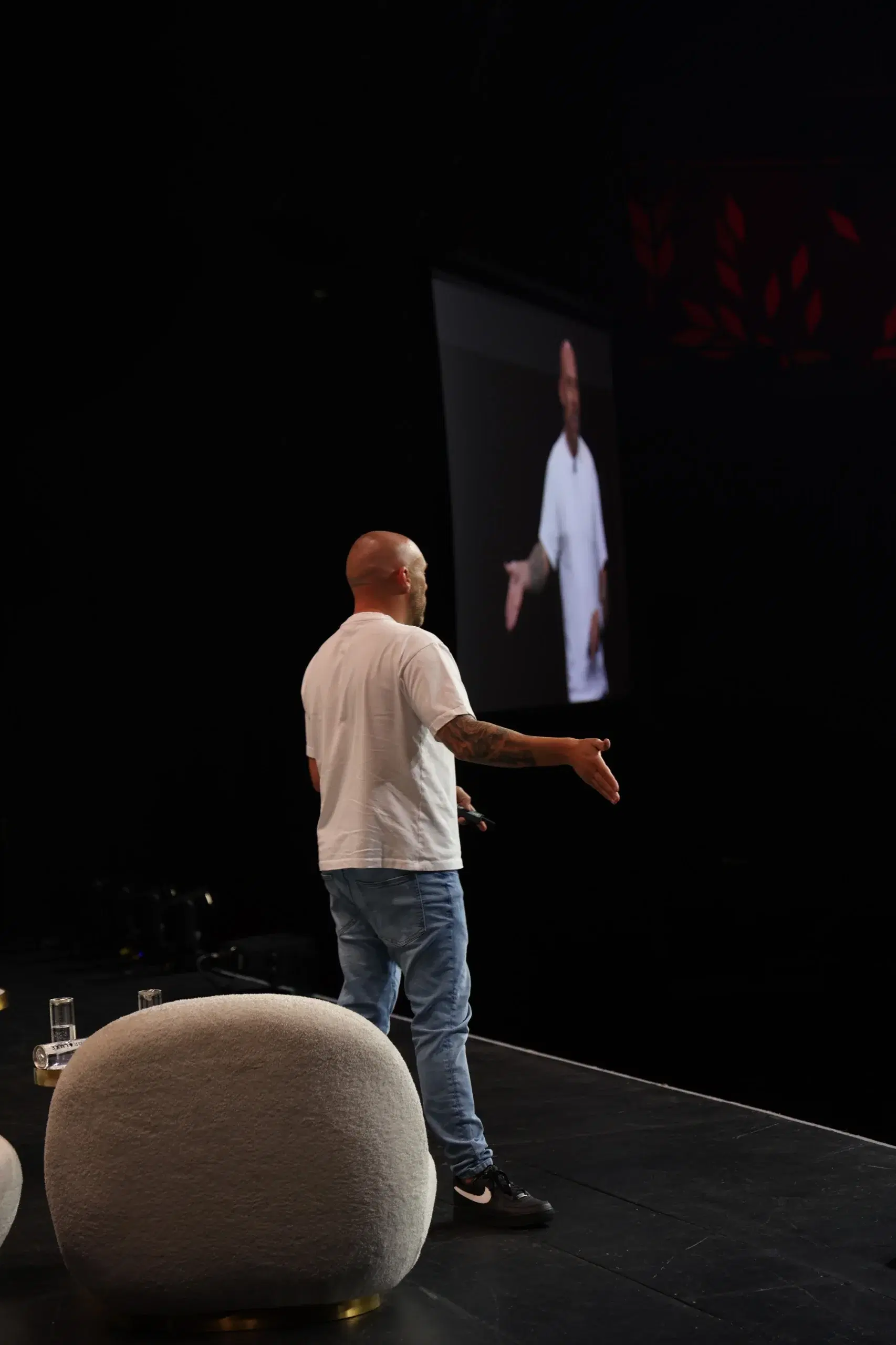 Joshua on stage beside the presentation screen
